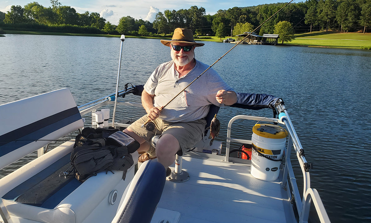 Smiling man fishing on pontoon boat