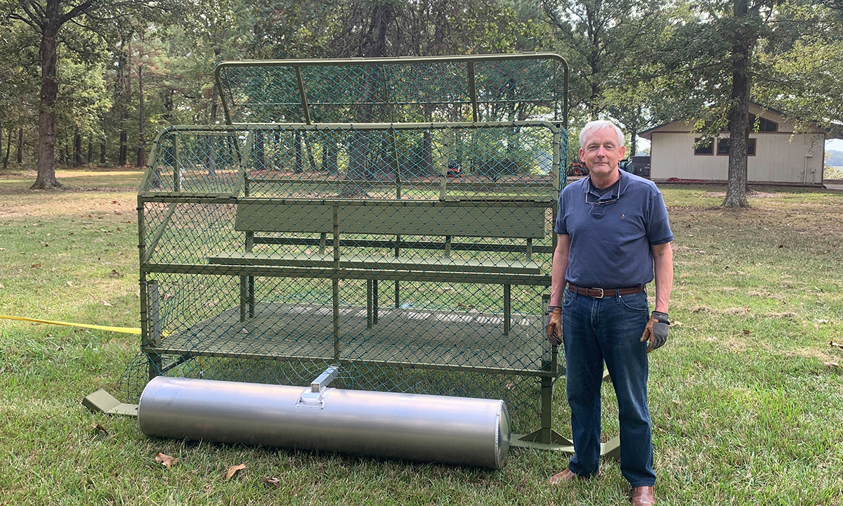 man standing next to duck blind